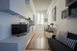 uma sala de estar com um sofá e uma cozinha com uma televisão em Biennale Apartments Venice em Veneza