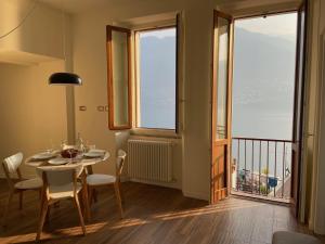 a dining room with a table and chairs and a window at Via Castello, Lake Como, Brienno in Brienno