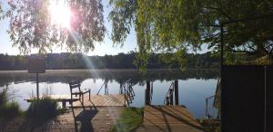 a bench sitting on a dock next to a lake at Highland Accommodation Bavaria in Weilheim in Oberbayern