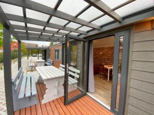 a pergola on a deck with a table and benches at Domy nad morzem - Chata Pirata- Tiny House in Dziwnów