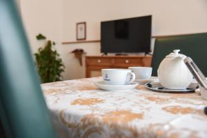 a table with two cups and a teapot on it at HOTEL DIANA apartments in Prague