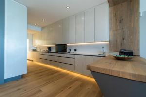 a kitchen with white cabinets and a wooden counter top at Bayview 303 in Hermanus
