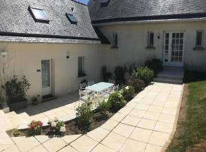 une terrasse avec une table en face d'une maison dans l'établissement Gîte la Briantaise, à Saint-Malo