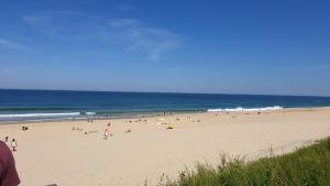 un gruppo di persone su una spiaggia vicino all'oceano di 3 chambres mimizan gastes biscarrosse camping siblu a Gastes