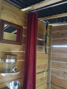 a room with a red curtain in a log cabin at Yourte Mont-Saint-Michel in Jullouville-les-Pins