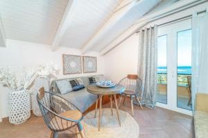 sala de estar con mesa, sillas y sofá en Niver Luxury Suites, en Lefkada