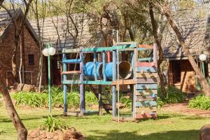 a playground in front of a house at First Group Magalies Park in Hartbeespoort