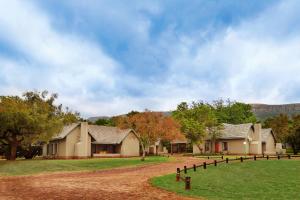 a group of houses with trees and mountains in the background at First Group Magalies Park in Hartbeespoort