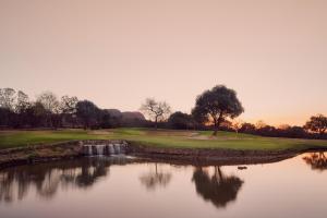 a view of a golf course with a pond at First Group Magalies Park in Hartbeespoort