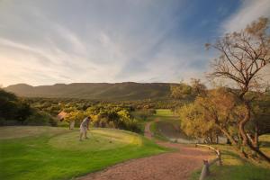 una persona está jugando al golf en un campo de golf en First Group Magalies Park, en Hartbeespoort