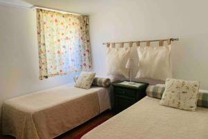 龐特維德拉的住宿－Pedreiras Cottage Rias Baixas，一间卧室设有两张床和窗户。