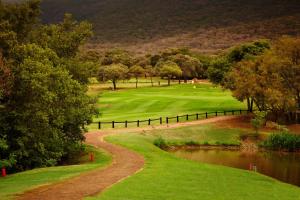 uitzicht op een golfbaan met een vijver bij First Group Magalies Park in Hartbeespoort