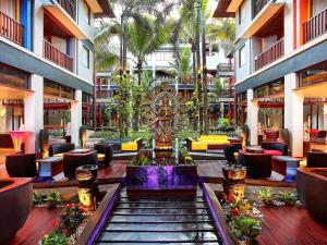 a lobby with a fountain in the middle of a building at Mercure Kuta Bali in Kuta