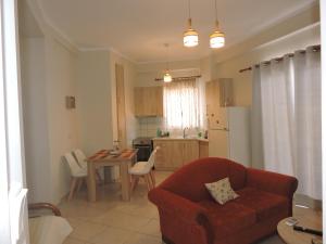 ein Wohnzimmer mit einem roten Sofa und einer Küche in der Unterkunft Sweet Suites in Amaliada