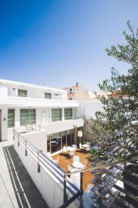 a large white building with a balcony with a table at Hotel Praia in Nazaré