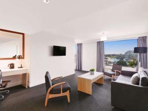 a living room with a couch and a table at Mercure Melbourne Albert Park in Melbourne