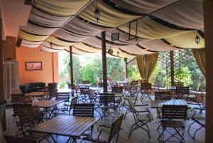 a restaurant with tables and chairs under a tent at Vila Veche in Haţeg