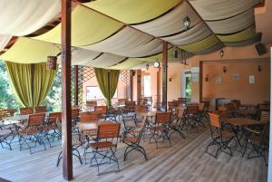 un ristorante con tavoli e sedie sotto una tenda di Vila Veche a Haţeg