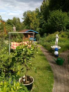 un jardín con una estatua de un gato y una fuente en Frauenpension Arleta - Women only, en Goslar