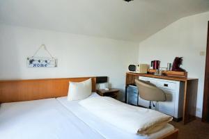 1 dormitorio con cama, escritorio y silla en Hotel Garni Liberia, en Oberstdorf