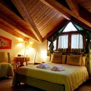 a bedroom with a large bed with a wooden ceiling at B&B Domus Traiani Benevento in Benevento