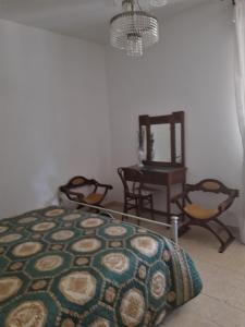 een slaapkamer met een bed en stoelen en een spiegel bij Da Franca in Assisi