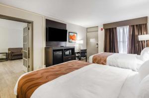 a hotel room with two beds and a flat screen tv at Quality Inn in Bristol