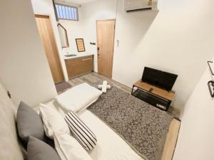 a small room with a bed and a television at Vann Bangkok Boutique House in Bangkok