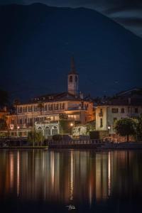 ein großes Gebäude mit einem Uhrturm oben in der Nacht in der Unterkunft Hotel Due Palme in Mergozzo