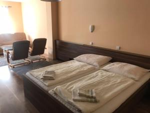 1 cama grande en una habitación con 2 sillas en Bezměrovský dvůr Kroměříž en Kroměříž