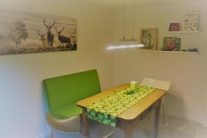 ein Esszimmer mit einem grünen Tisch und Stühlen in der Unterkunft Ferienwohnung Ströbele in Müllheim