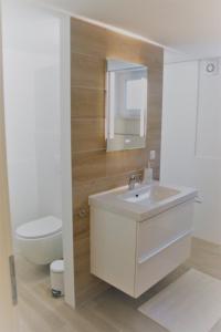 ein Badezimmer mit einem weißen Waschbecken und einem WC in der Unterkunft Ferienwohnung Ströbele in Müllheim