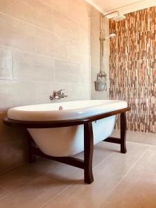 a bath tub in a bathroom with a shower at A Villa by the Sea Bed & Breakfast in Vila Franca do Campo