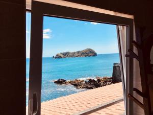 a window view of the ocean from a house at A Villa by the Sea Bed & Breakfast in Vila Franca do Campo