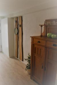 ein Zimmer mit einem Holzschrank mit einer Pflanze darauf in der Unterkunft Ferienwohnung Ströbele in Müllheim