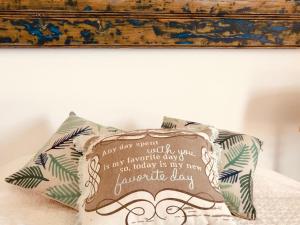 a pillow sitting on a bed with a painting above it at A Villa by the Sea Bed & Breakfast in Vila Franca do Campo