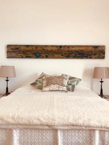 a bedroom with a white bed with two lamps at A Villa by the Sea Bed & Breakfast in Vila Franca do Campo