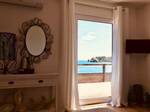 a door to a balcony with a view of the ocean at A Villa by the Sea Bed & Breakfast in Vila Franca do Campo