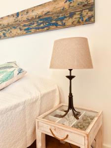a lamp on a table next to a bed at A Villa by the Sea Bed & Breakfast in Vila Franca do Campo