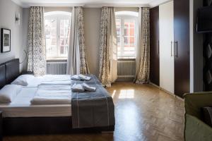 a bedroom with two beds and two windows at Apart-Hotel Heiligenthaler Hof in Landau in der Pfalz