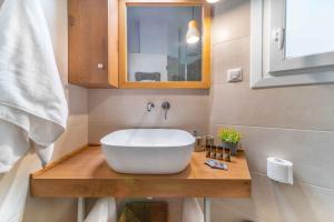ein Badezimmer mit einem großen weißen Waschbecken auf einer Holztheke in der Unterkunft Suites 05-06 - Smart Cozy Suites - Large 2 bedroom, near Athens and metro in Athen