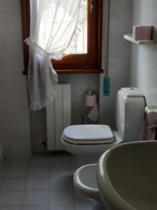 La salle de bains est pourvue de toilettes, d'un lavabo et d'une fenêtre. dans l'établissement Stanza Angiolina, à Forte dei Marmi