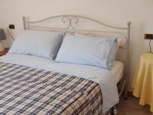 un letto con lenzuola e cuscini bianchi in una stanza di Stanza Angiolina a Forte dei Marmi