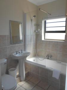 La salle de bains est pourvue d'un lavabo, de toilettes et d'une baignoire. dans l'établissement Shearwater on Sea, Myoli, Sedgefield, à Sedgefield