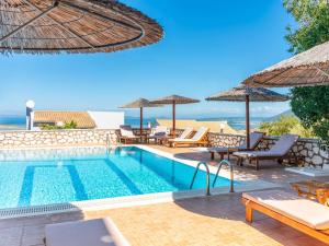 a swimming pool with chairs and umbrellas at Niver Luxury Suites in Lefkada Town