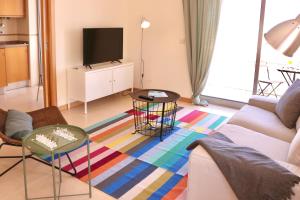 ein Wohnzimmer mit einem Sofa und einem TV in der Unterkunft Ocean Terrace - Private Patio with BBQ & Sea view in Nazaré