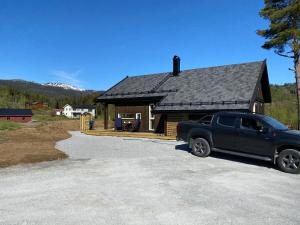a black truck parked in front of a house at Tuddal Hyttegrend HYTTA KÅNS in Hjartdal