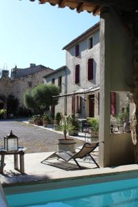 a house with a pool and a chair next to a building at L'Albane Chambres d'hôtes in Lauraguel