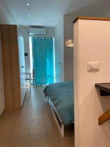 een slaapkamer met een bed en een blauw gordijn bij Namastè monolocale in Ancona