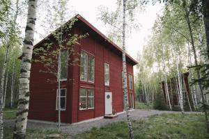 una casa roja en medio de un bosque en STF Tåtorp Cafe & Logi Göta Kanal, en Tåtorp